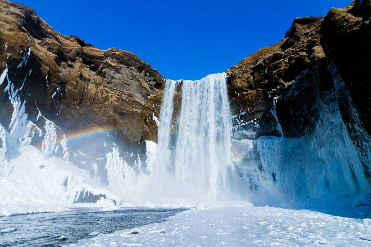 Alpine climber inspecting ice piton temperature effect after partial pull-out in mixed conditions